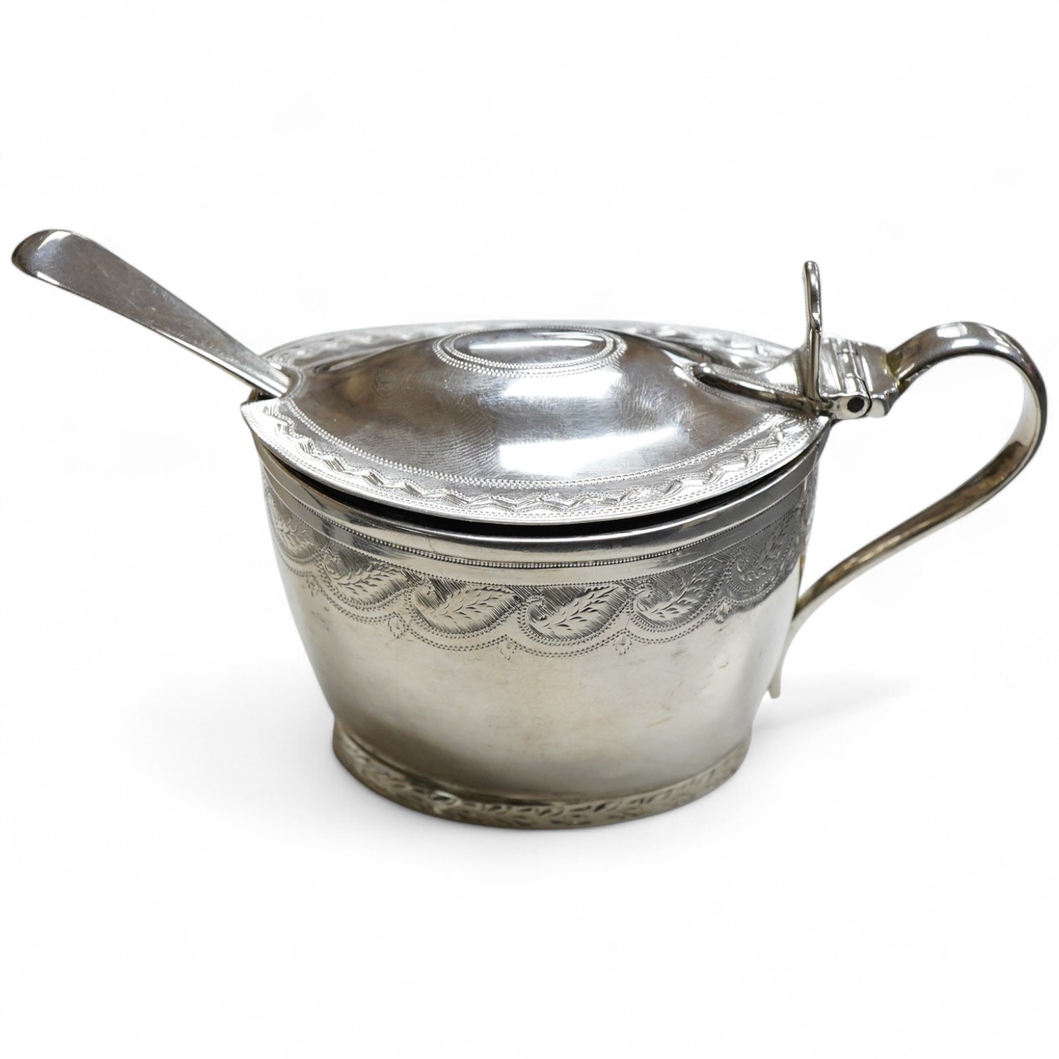 A George III engraved oval silver mustard pot, by James Mince, London, 1805, height 69mm, together with an associated silver mustard ladle, Thomas Dicks, London, 1808.